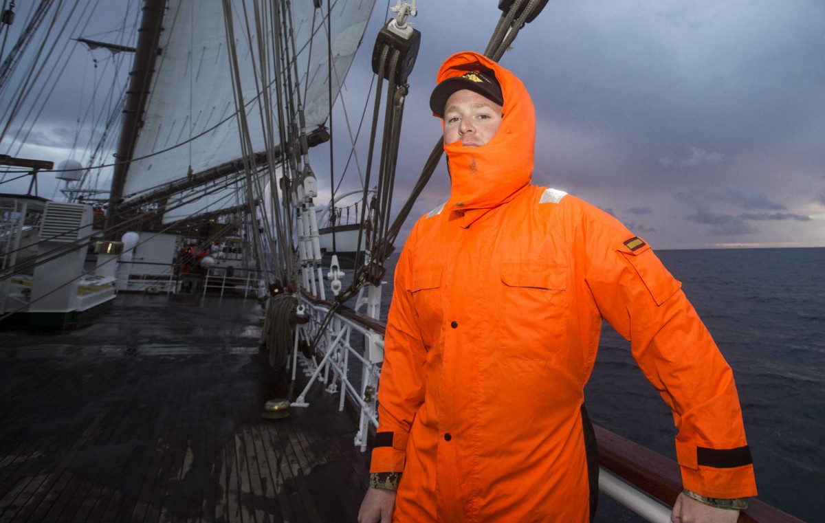 Tripulante de Elcano con el mono naranja de lluvia / A. Vázquez