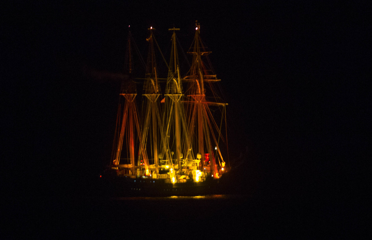 El Juan Sebastián de Elcano iluminado con la bandera de España, fondeado en la Bahía. Foto: Antonio Vázquez